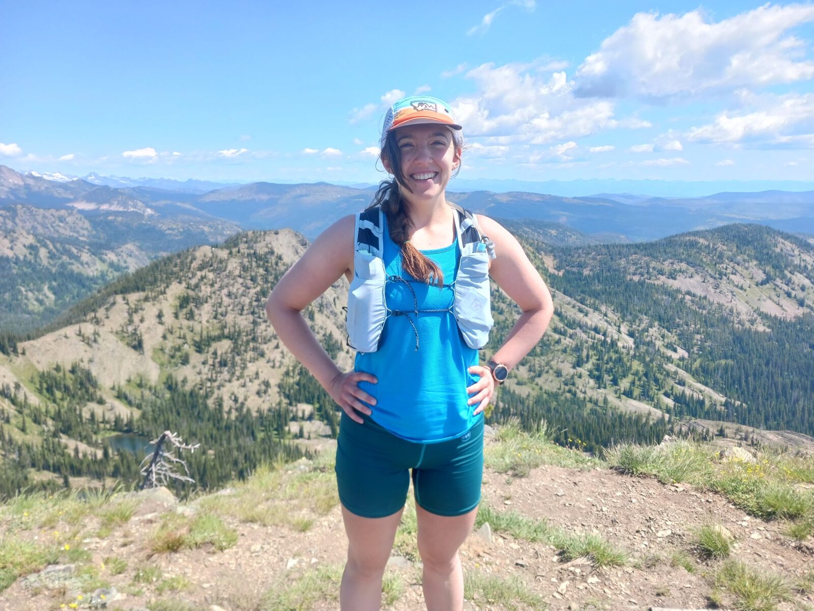 Portrait of Emma Hauser, standing at the top of a mountain wearing hiking gear