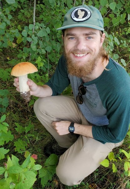 Portrait of Lang DeLancey holding a mushroom